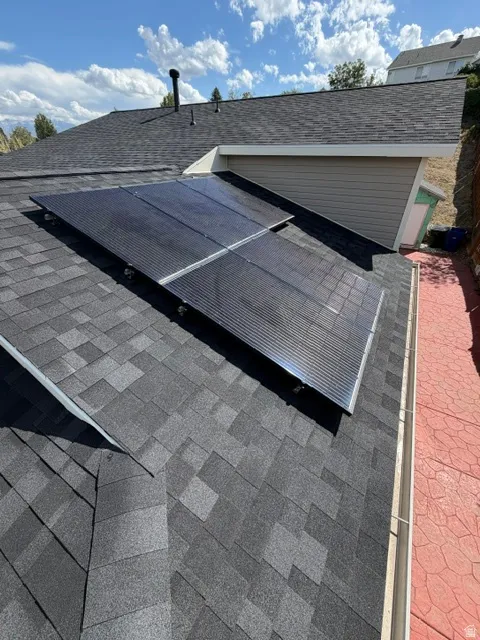 Asphalt shingle roof with solar panels and a rain gutter