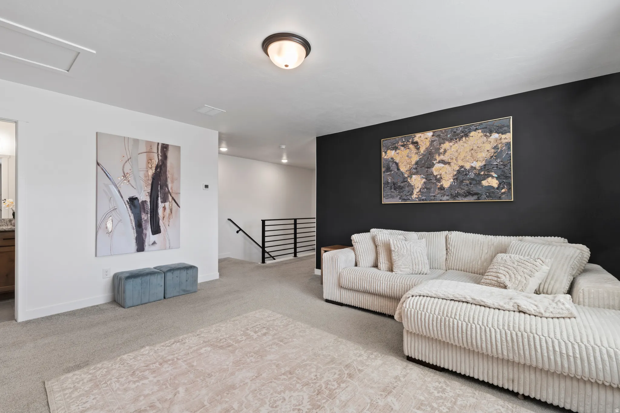 Carpeted living room featuring attic access and baseboards