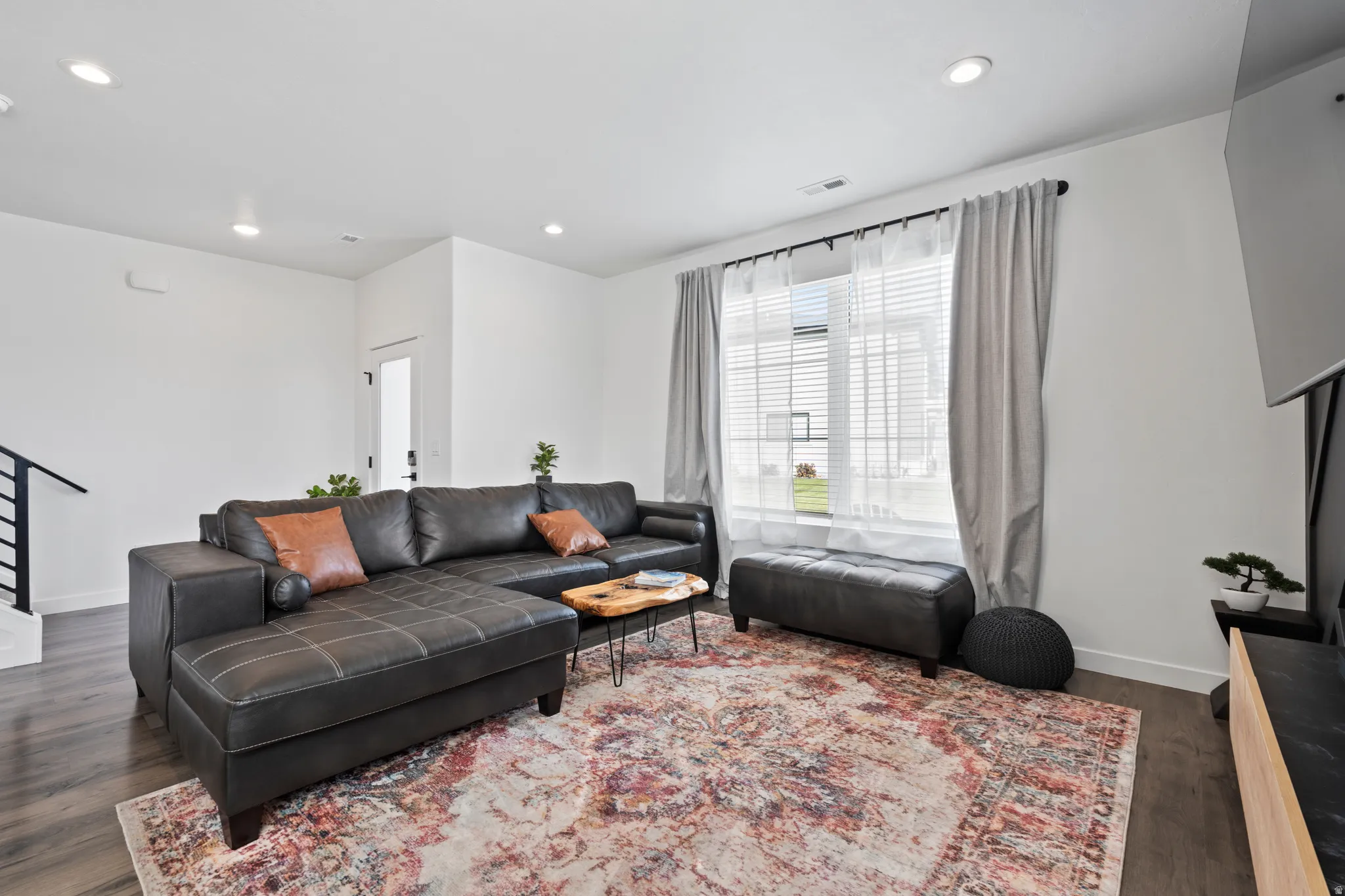 Living room featuring dark wood-style flooring and recessed lighting