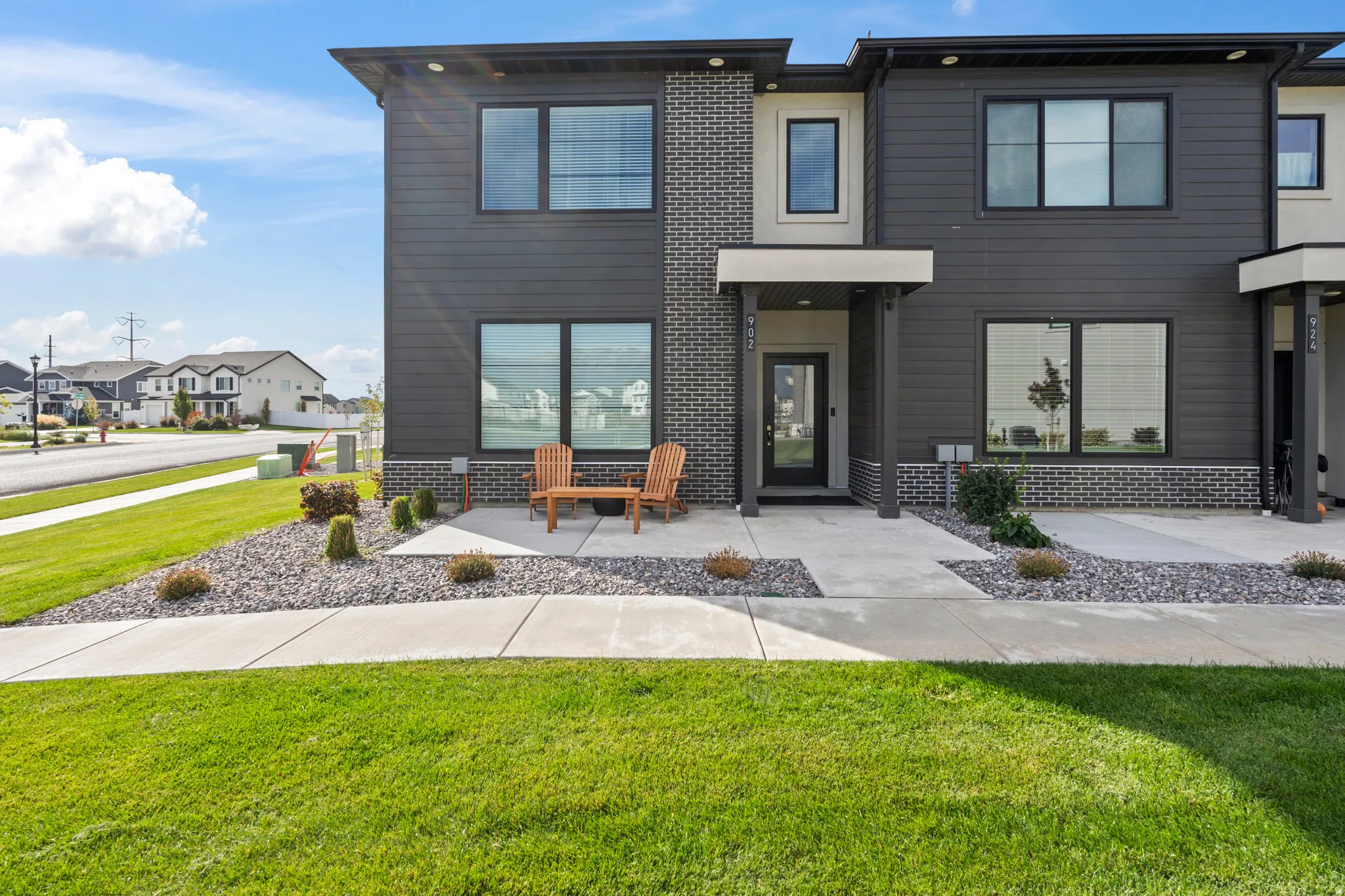 Modern home featuring a front lawn, brick siding, and a residential view