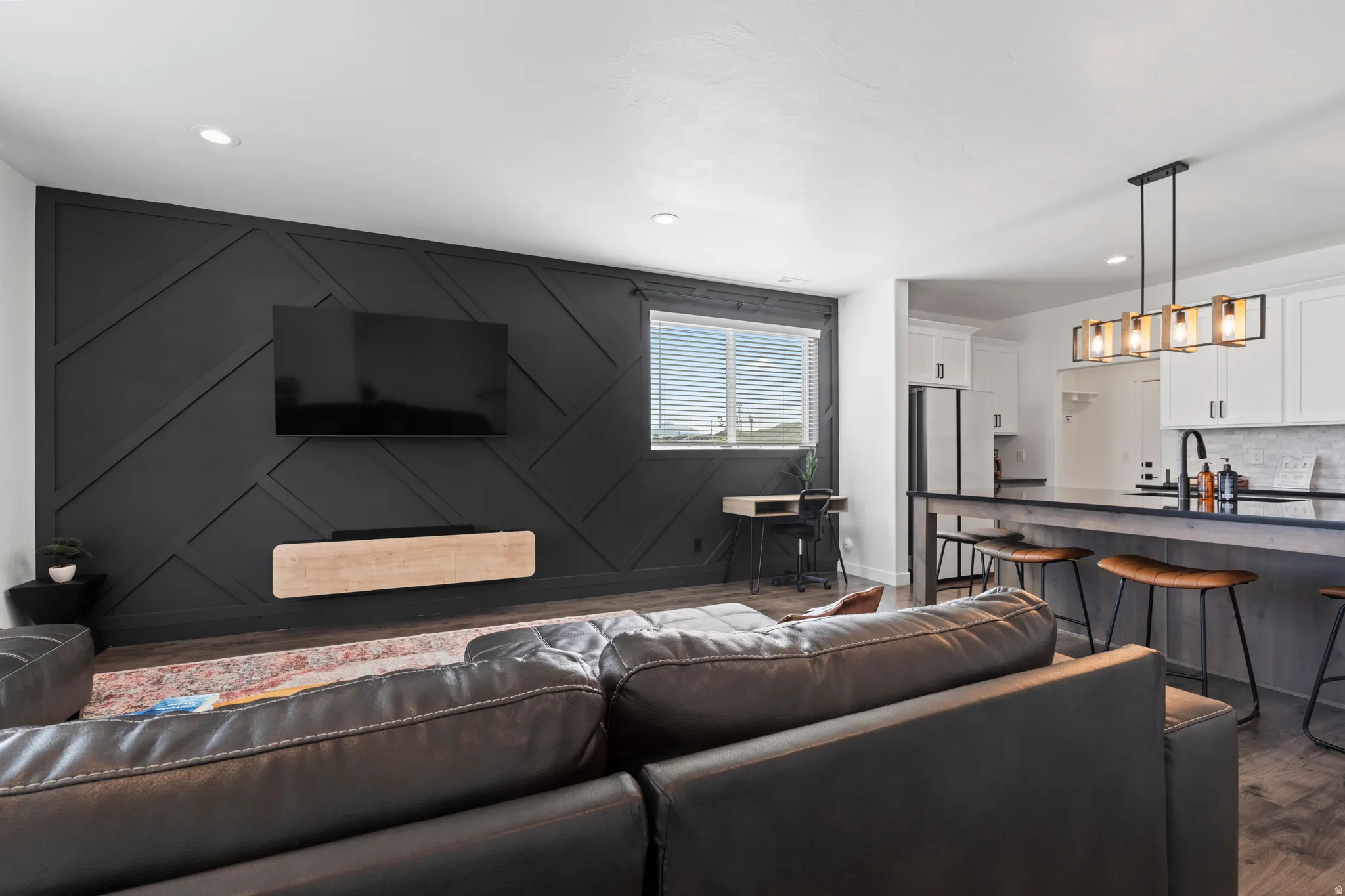 Living area with dark wood-type flooring and recessed lighting