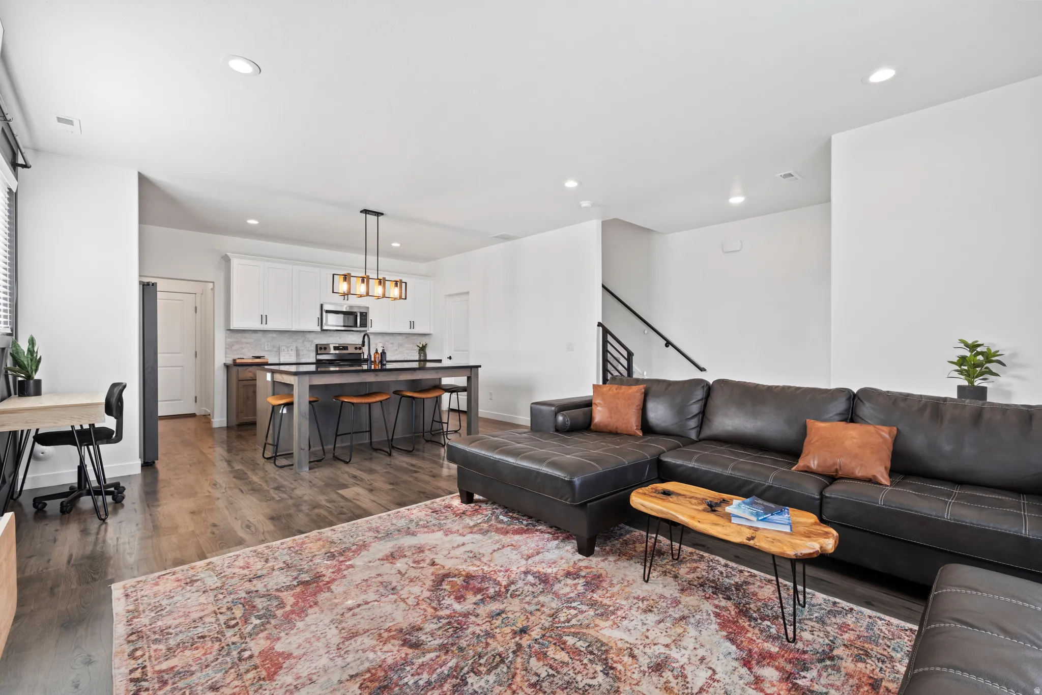 Living area with dark wood-type flooring and recessed lighting