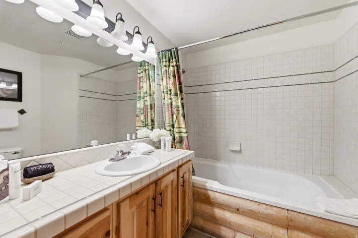 Bathroom featuring tiled shower / bath and vanity