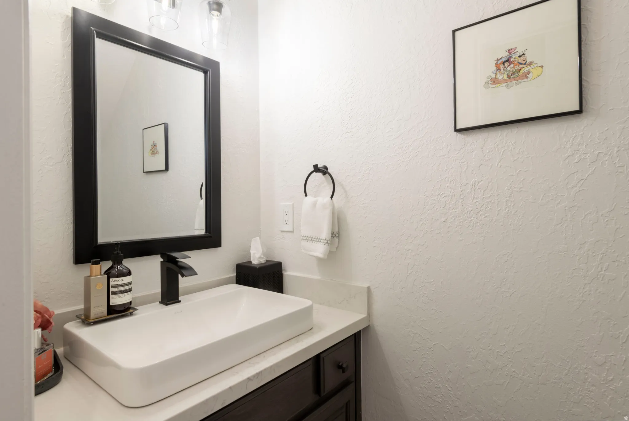 Bathroom featuring vanity and a textured wall