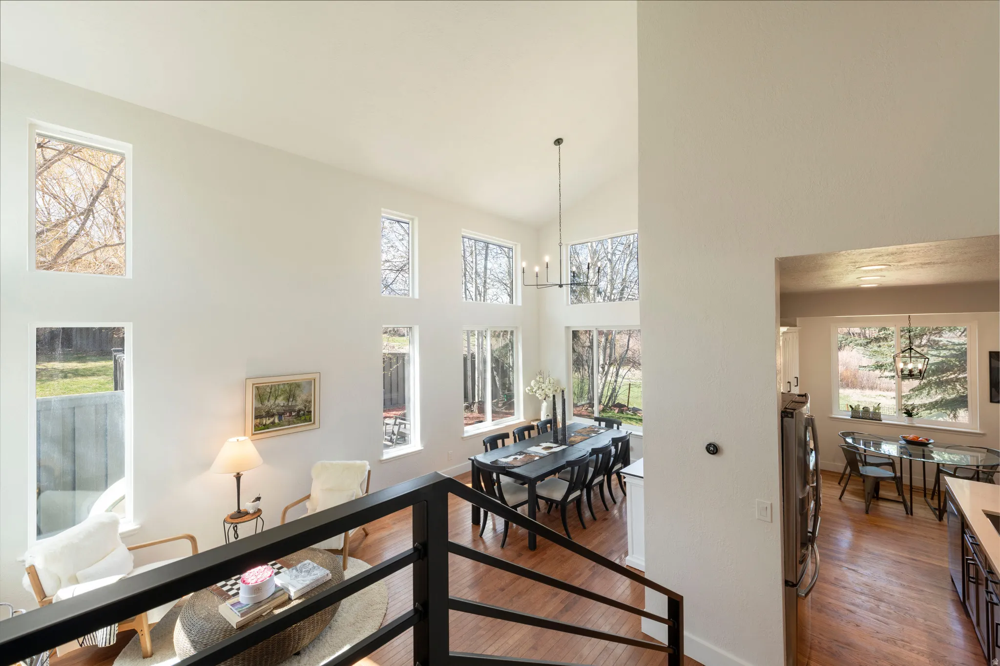 Hall featuring hanging lights, dark wood-type flooring, and lofted ceiling