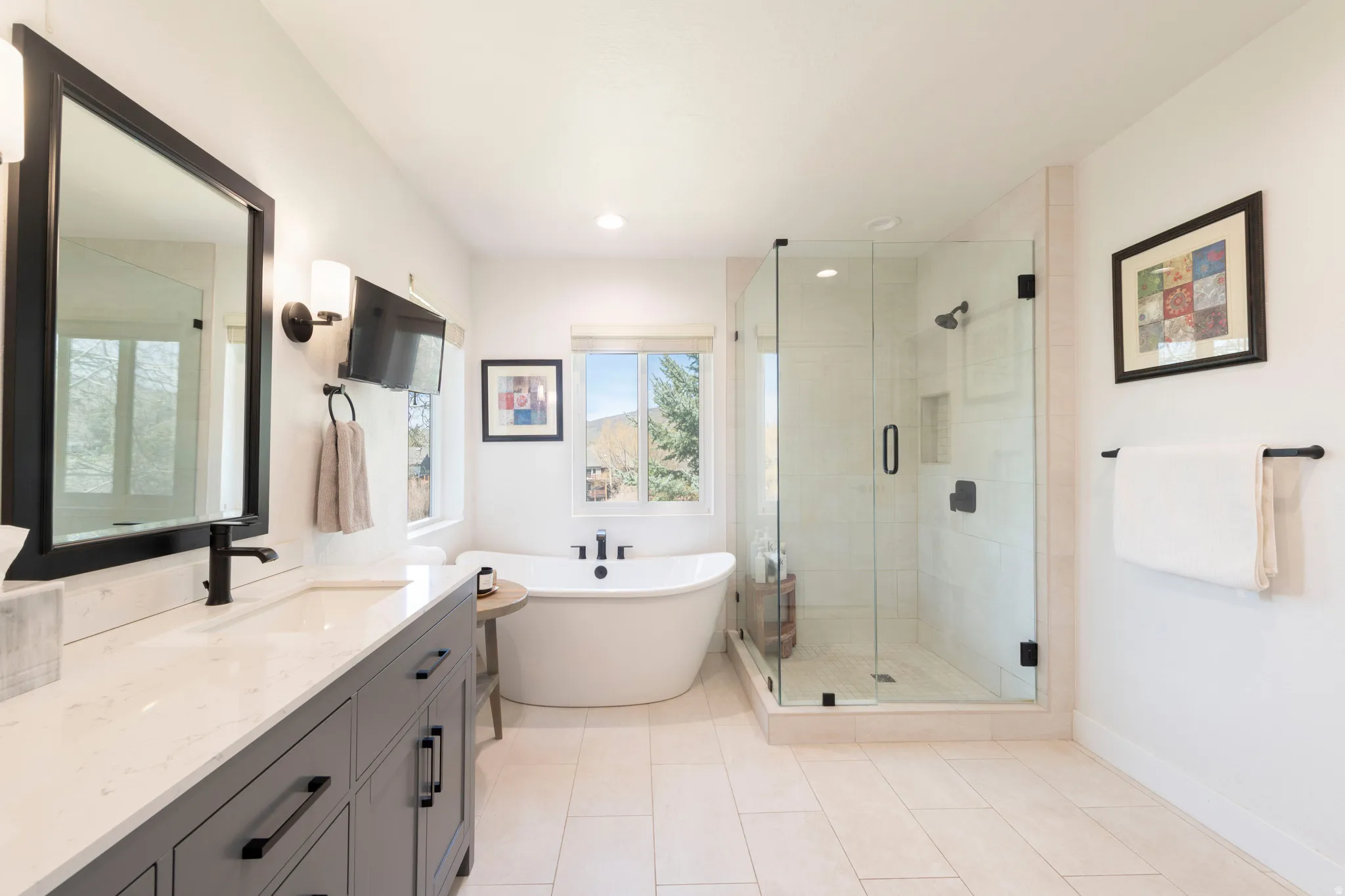 Full bath with vanity, a shower stall, a freestanding tub, light tile patterned floors, and recessed lighting