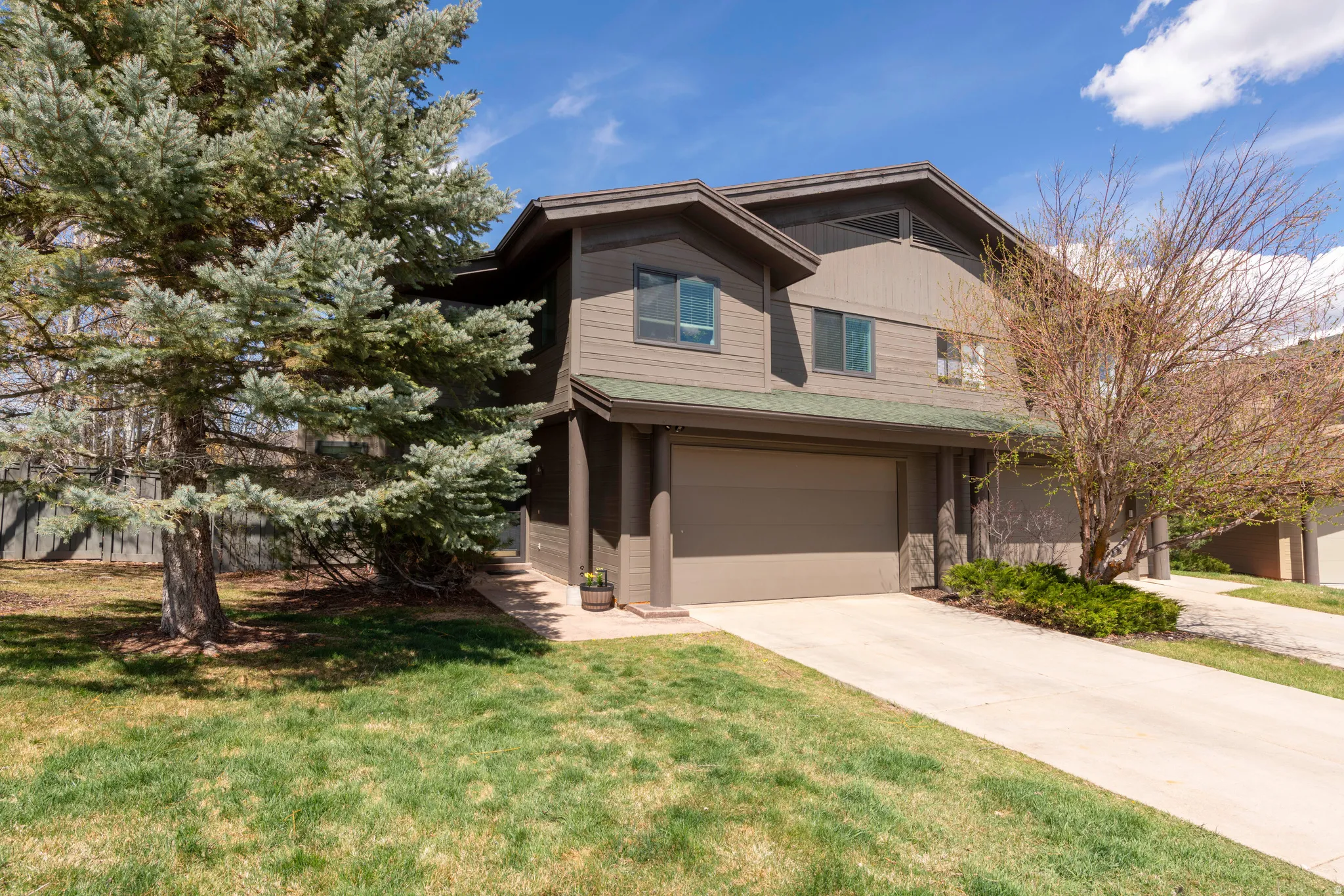 View of front facade with an attached garage, concrete driveway, and a front yard