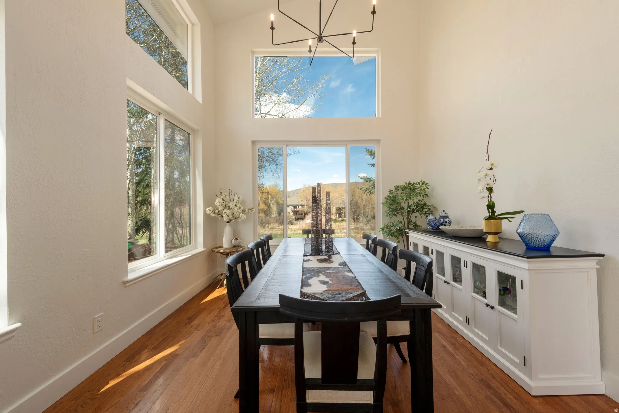 Dining space featuring a chandelier, dark wood-style floors, plenty of natural light, and vaulted ceiling