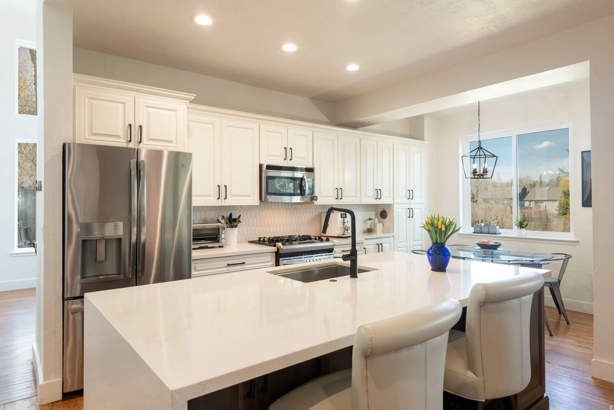 Kitchen featuring light wood-style floors, stainless steel appliances, and light stone counters