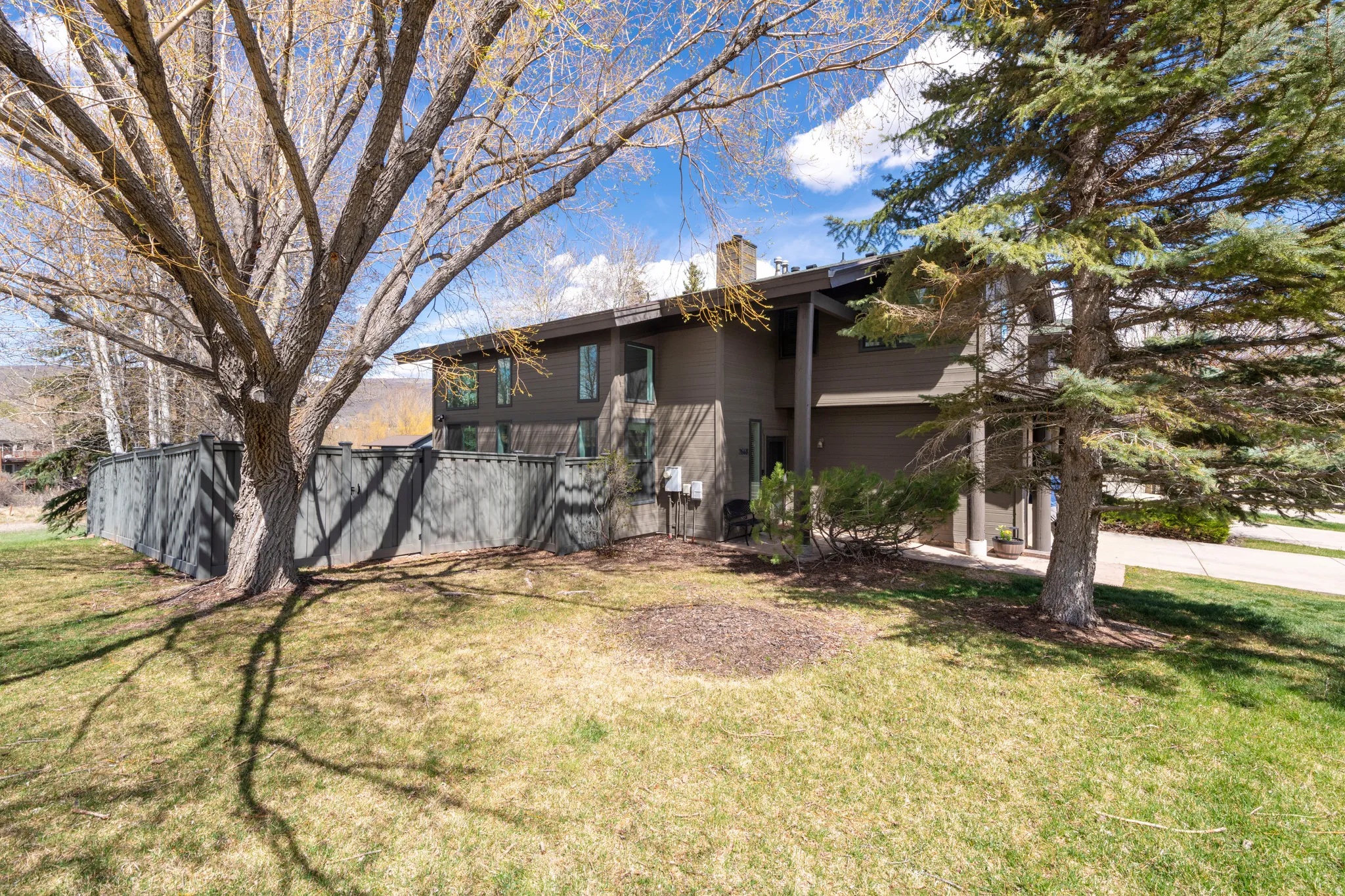View of front facade with a chimney, an attached garage, and concrete driveway