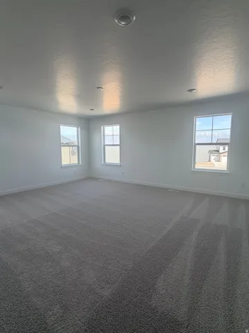 Unfurnished room featuring dark carpet and a textured ceiling