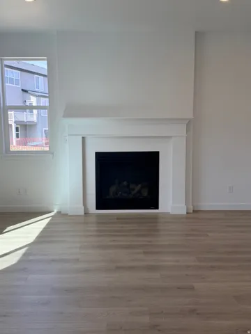 Detailed view of wood finished floors, a fireplace, and recessed lighting
