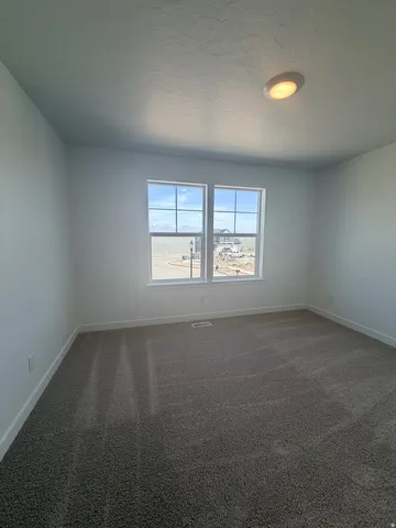 Spare room with dark carpet and a textured ceiling