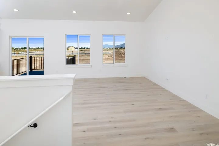 Spare room featuring light wood-type flooring, healthy amount of natural light, recessed lighting, and a mountain view