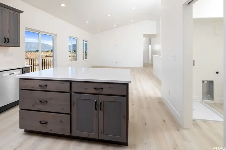 Kitchen featuring dishwasher, recessed lighting, light countertops, light wood-type flooring, and a kitchen island