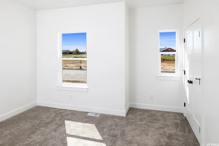 Carpeted empty room with baseboards