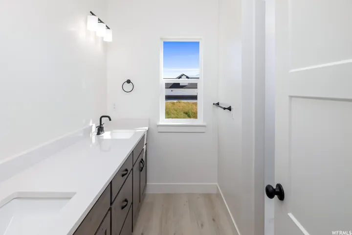 Bathroom with double vanity and light wood-style floors