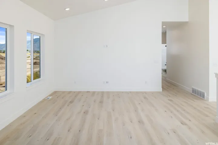 Spare room with light wood-style floors, recessed lighting, and a mountain view