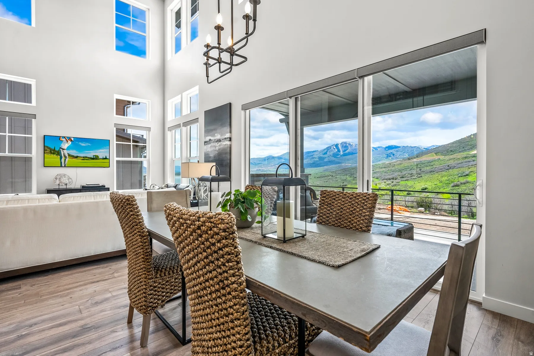 Dining area with hardwood / wood-style floors, a mountain view, and a high ceiling