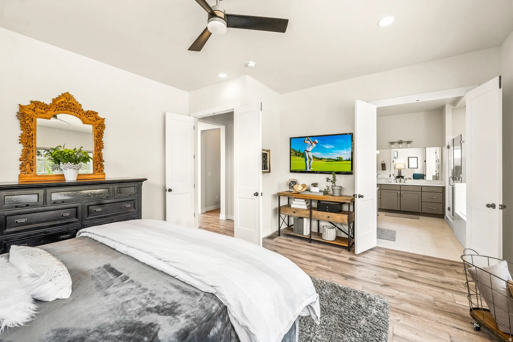 Bedroom with light wood-style floors, ceiling fan, connected bathroom, and recessed lighting