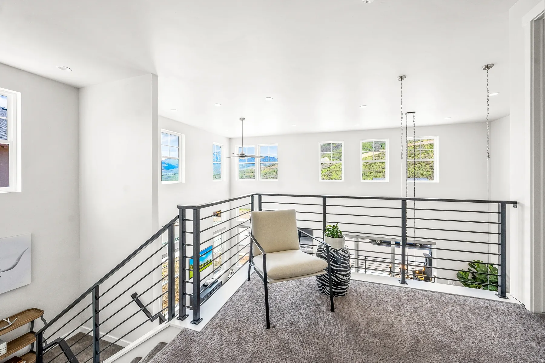 Living area featuring carpet, recessed lighting, and an upstairs landing
