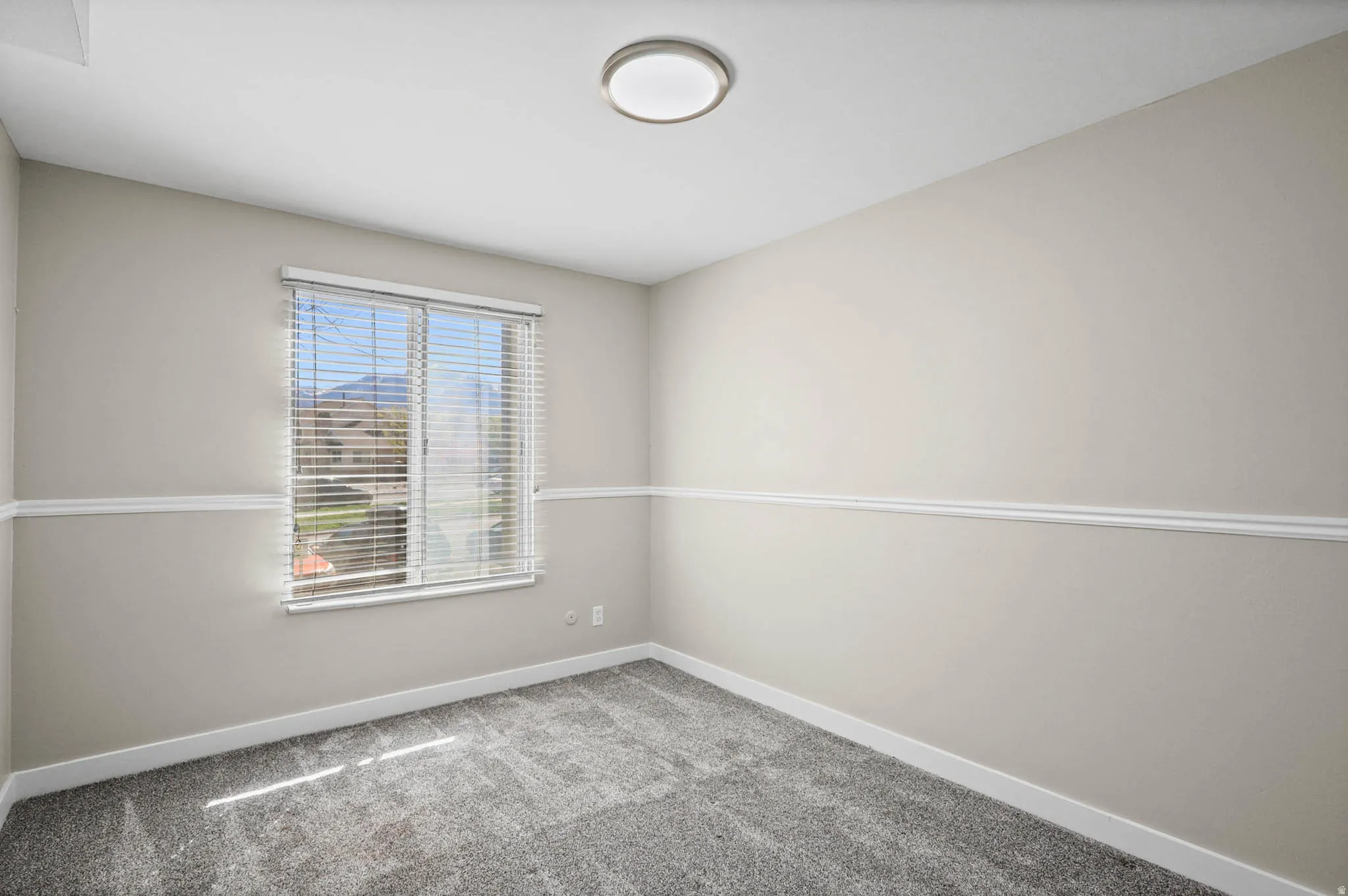Empty room with light carpet and baseboards