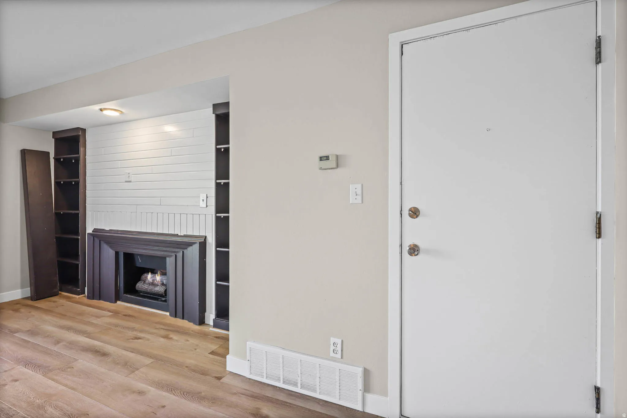 Unfurnished living room featuring light wood-type flooring and a fireplace