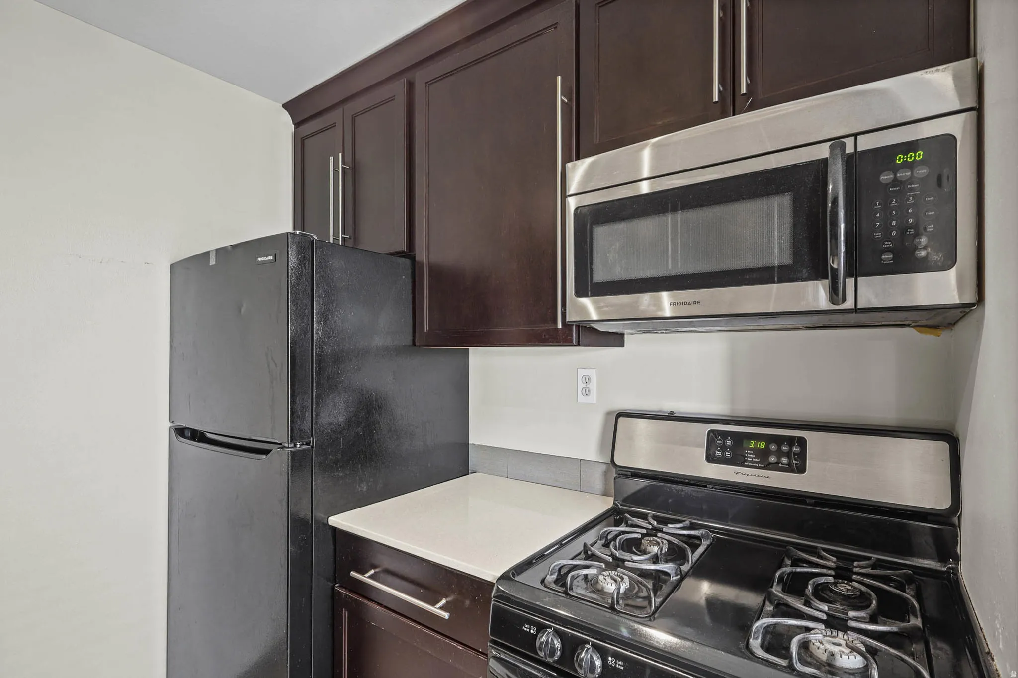 Kitchen with stainless steel appliances and dark wood finish cabinets
