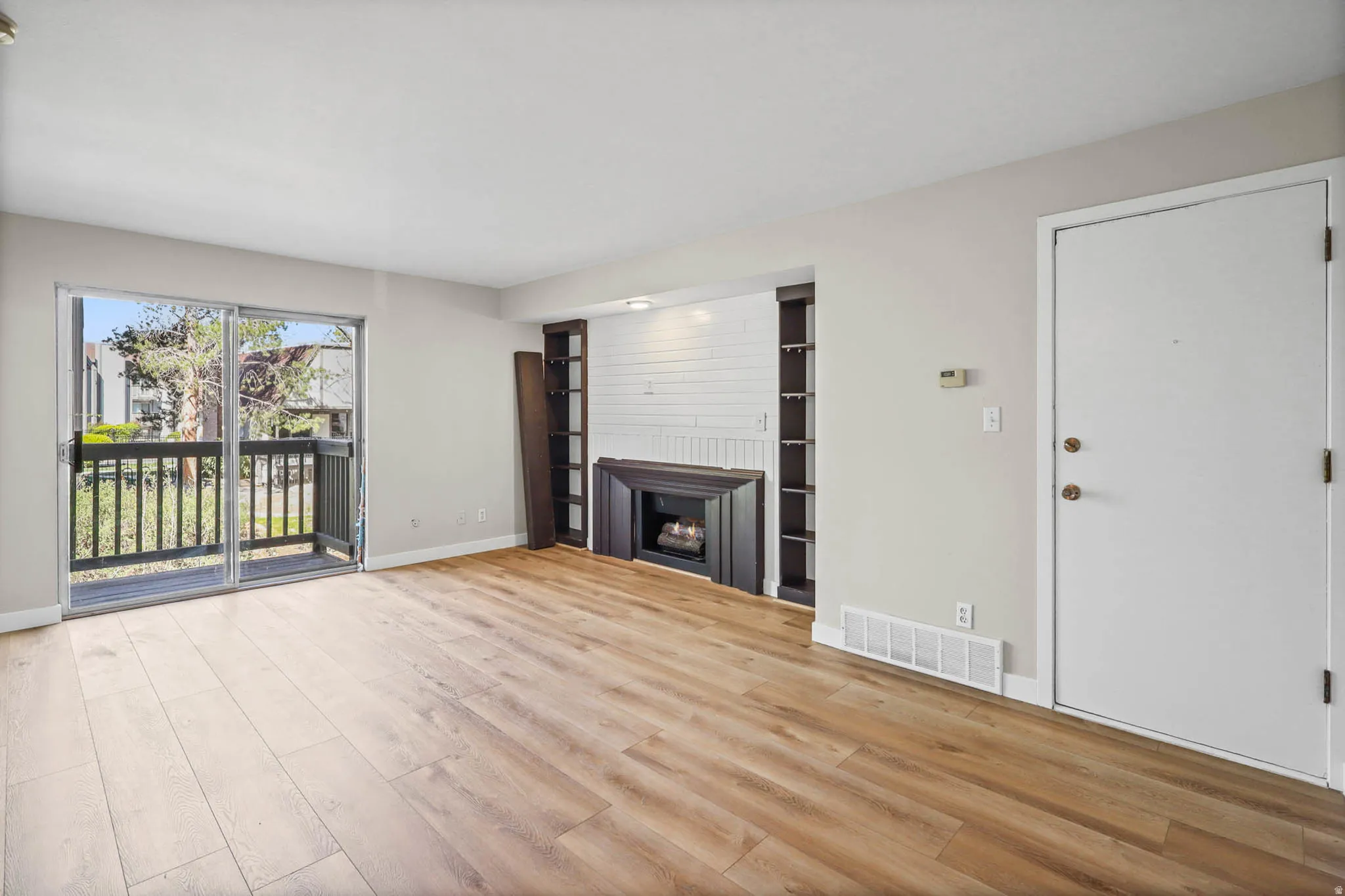 Unfurnished living room with light wood-style floors and a fireplace
