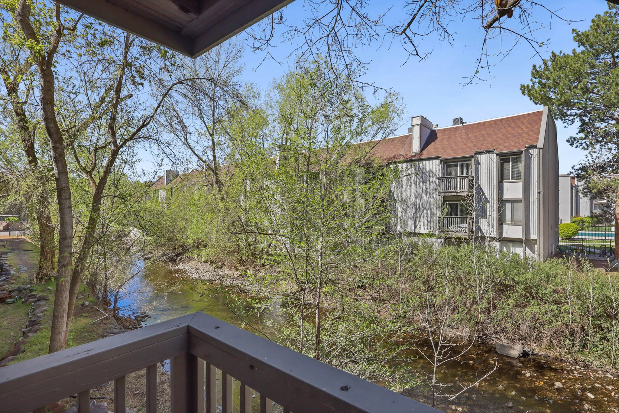 View of side of property with a balcony, a chimney, and a water view