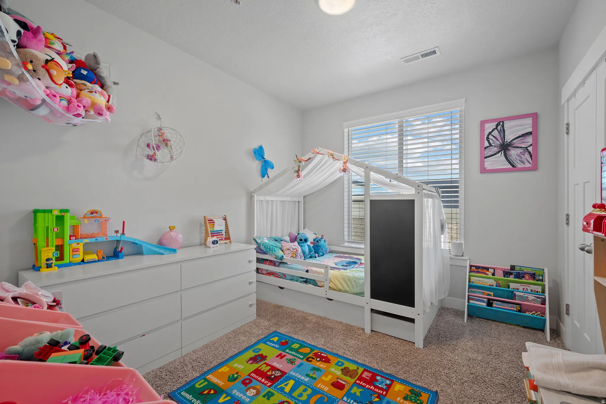 Bedroom with light carpet and a textured ceiling