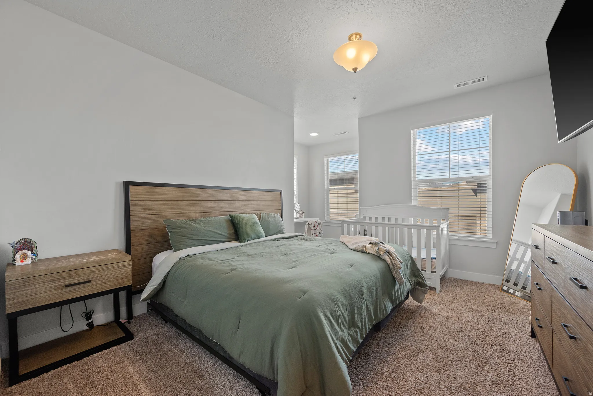 Bedroom featuring dark colored carpet and a textured ceiling