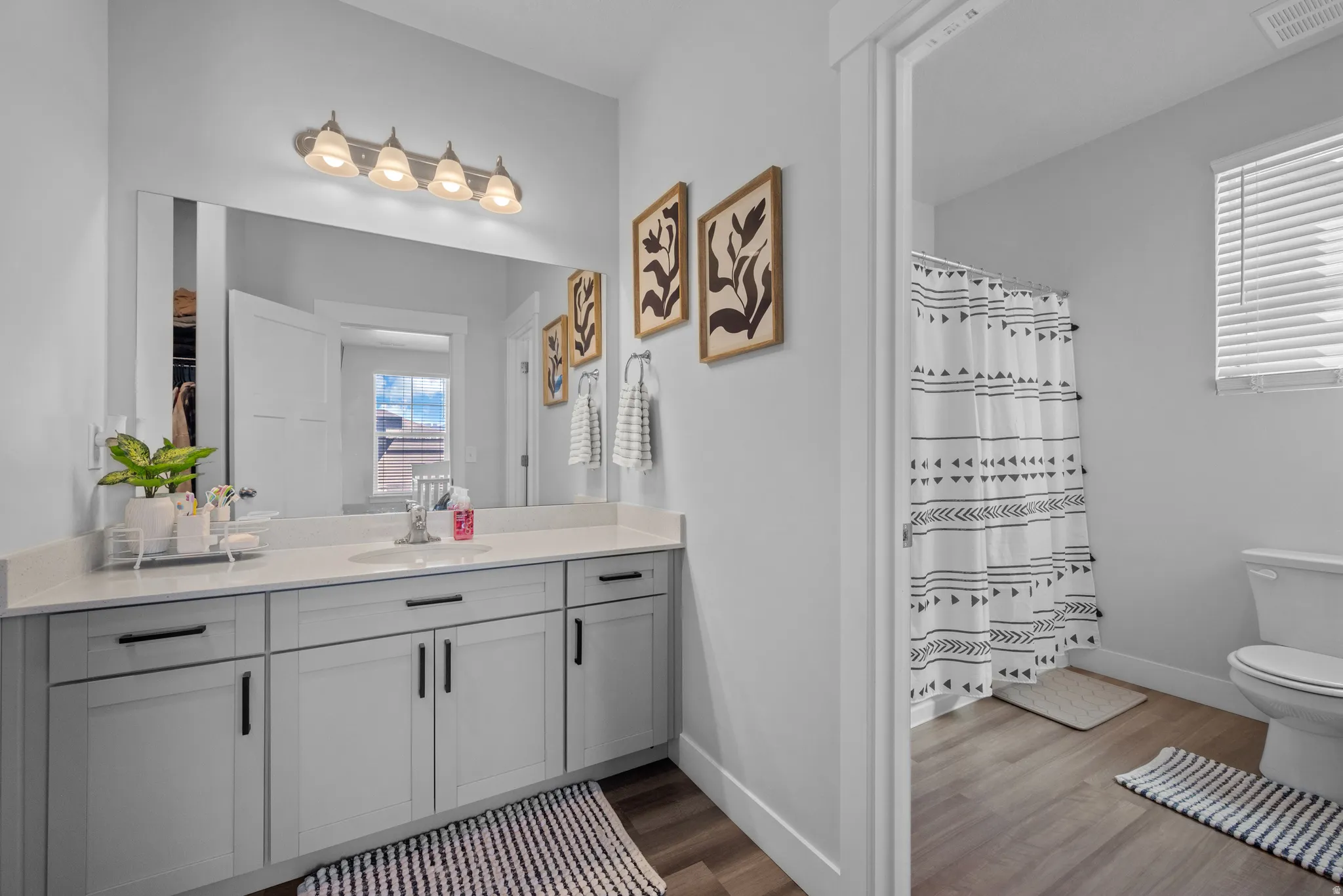 Full bathroom with vanity, a shower with curtain, and dark wood-style floors