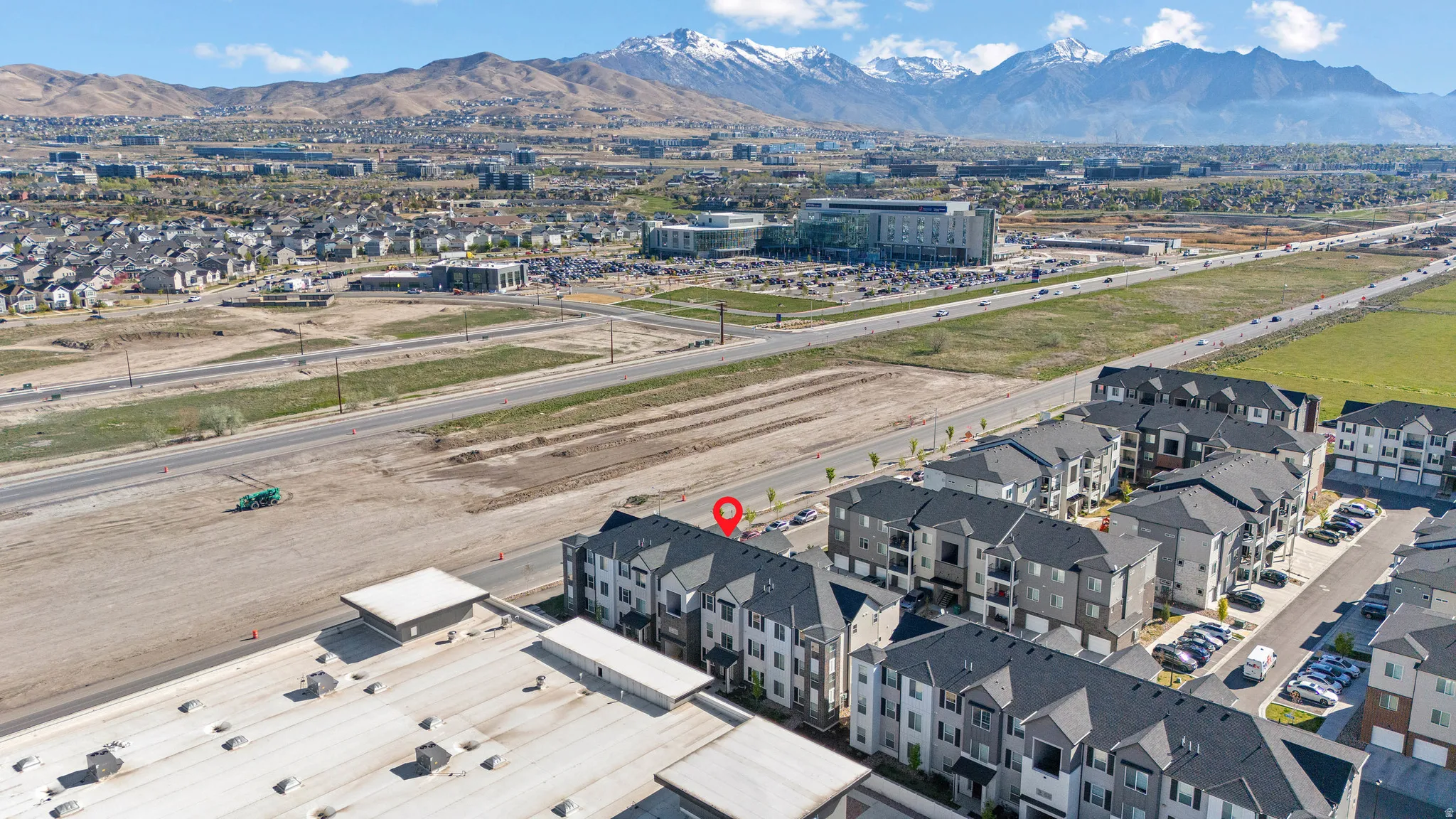 Aerial view of property and surrounding area with a mountainous background and nearby suburban area