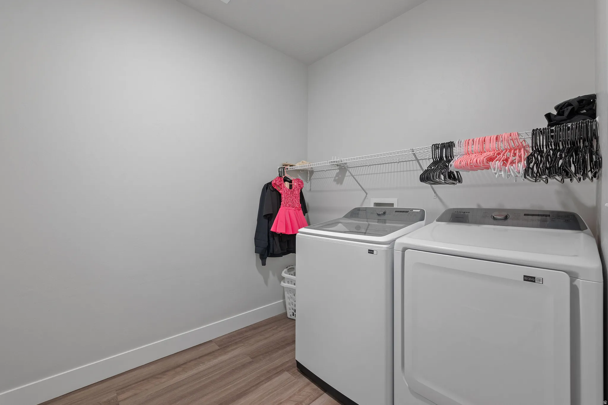 Laundry area featuring light wood-style floors and washing machine and dryer