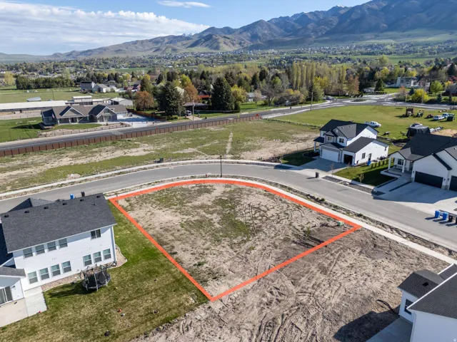 Aerial view of residential area with property boundaries highlighted and mountains