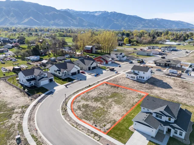 Aerial perspective of suburban area featuring property parcel outlined and a mountainous background
