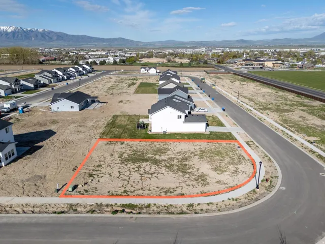 Aerial perspective of suburban area with property parcel outlined and mountains