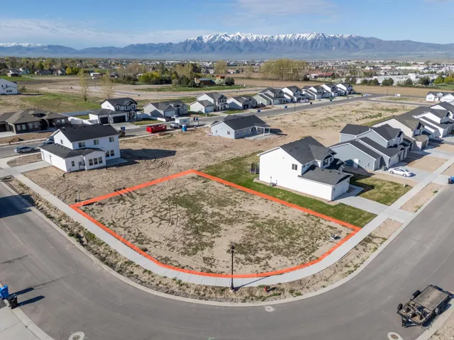 Aerial view of residential area featuring a mountainous background and property parcel outlined