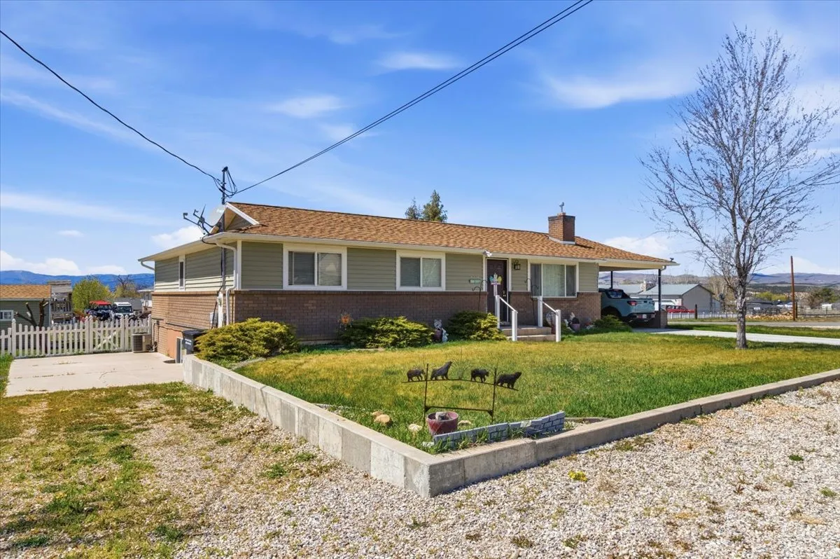 Single story home featuring brick siding, a chimney, covered porch, and a mountain view