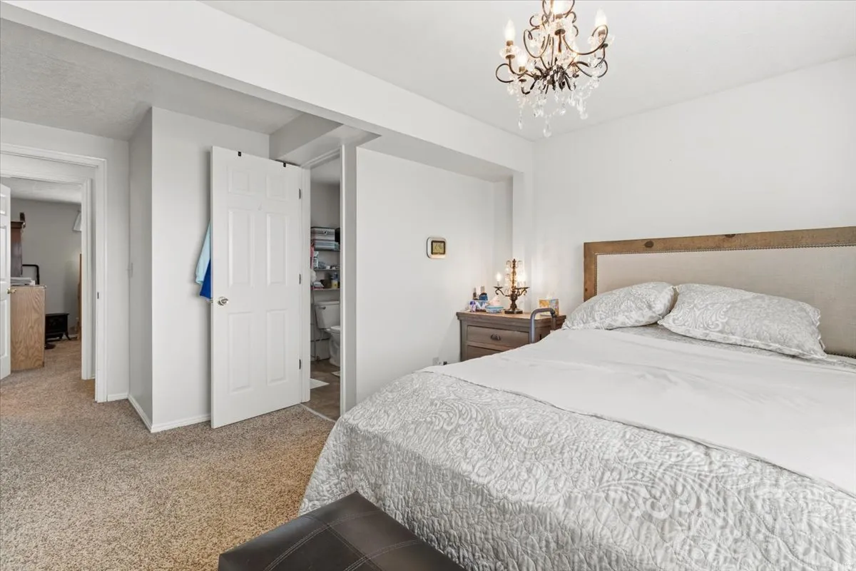 Bedroom featuring a chandelier and light carpet