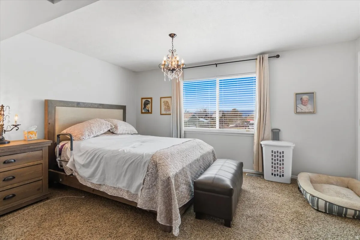 Bedroom with carpet floors and suspended lighting