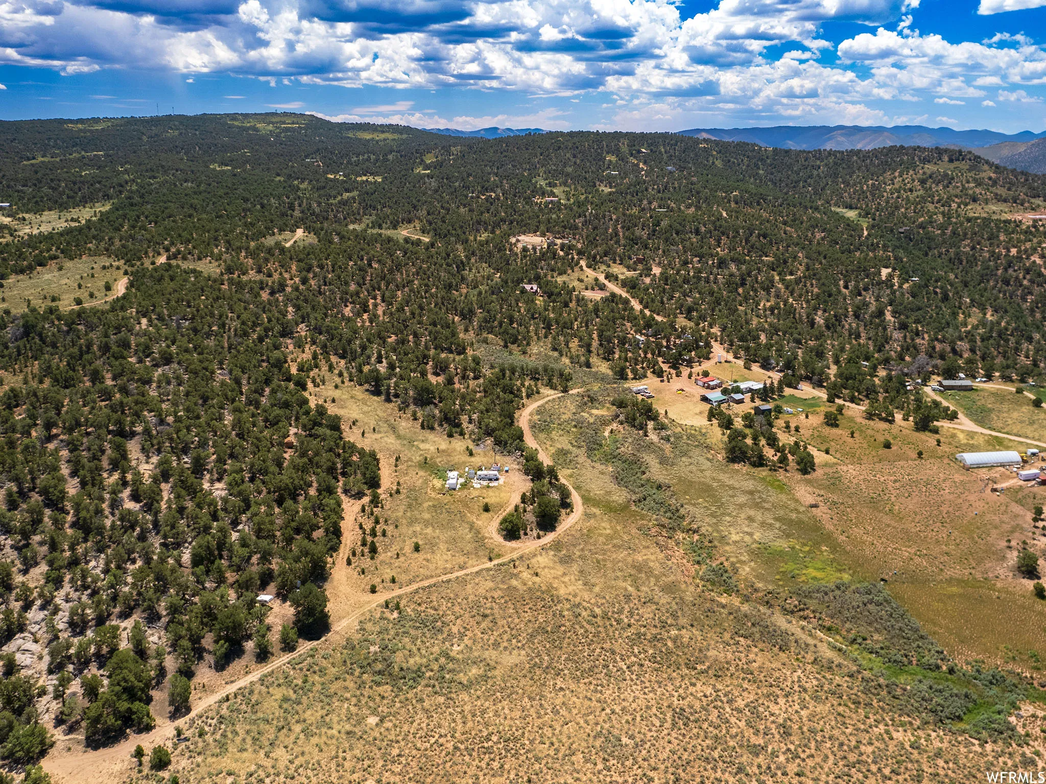 Drone / aerial view of a mountain backdrop and a heavily wooded area