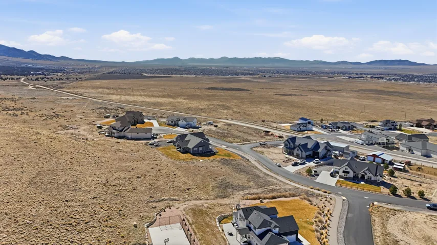 Aerial view of residential area featuring a mountainous background and a desert landscape