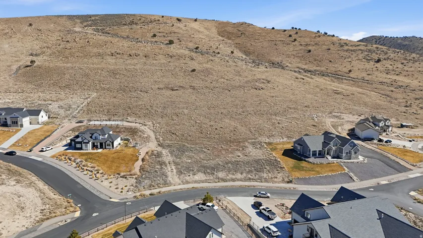 Aerial view of property and surrounding area with a mountain backdrop and nearby suburban area