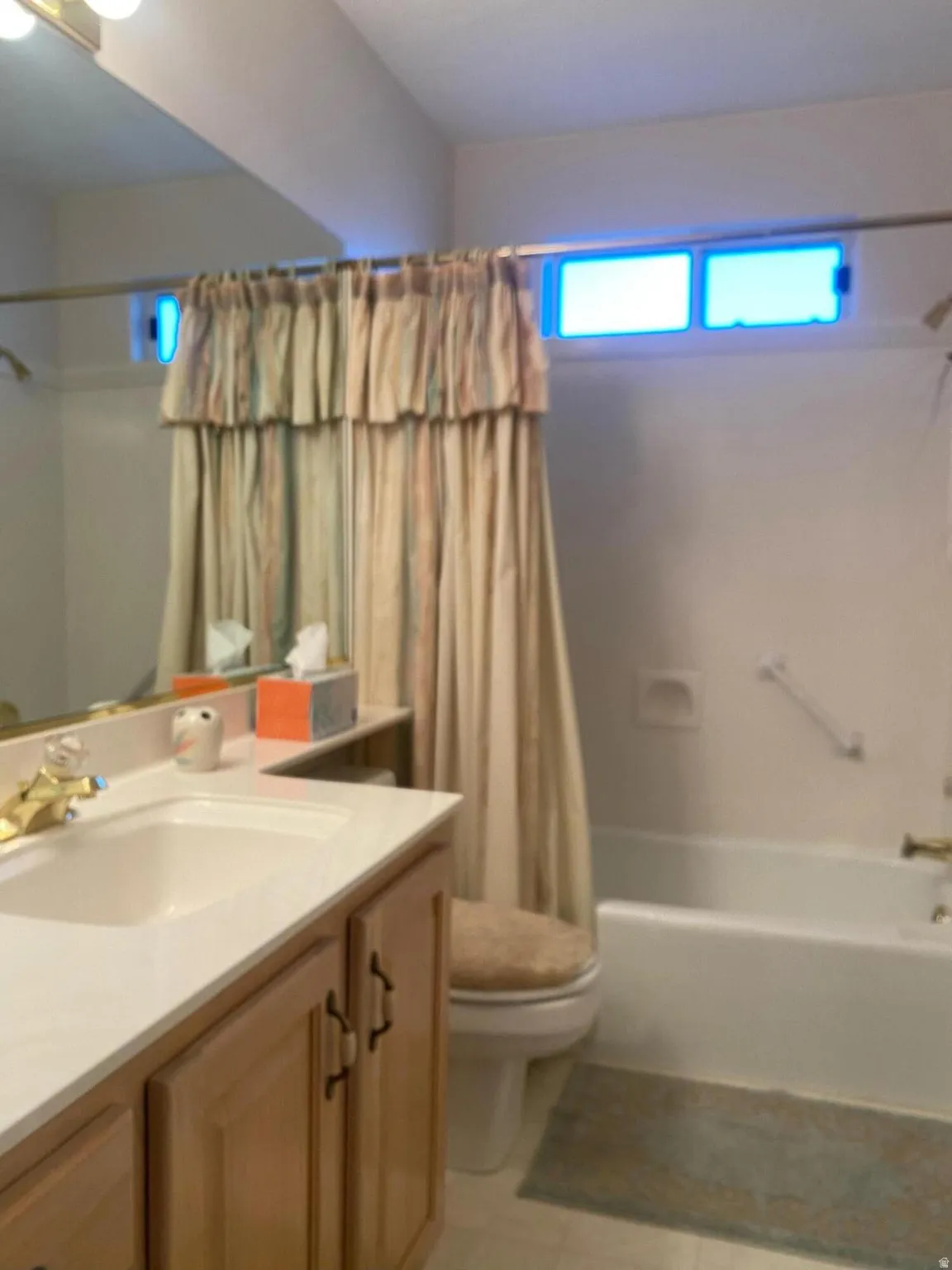 Bathroom featuring a vanity with light wood cabinetry, a white countertop, and an integrated sink