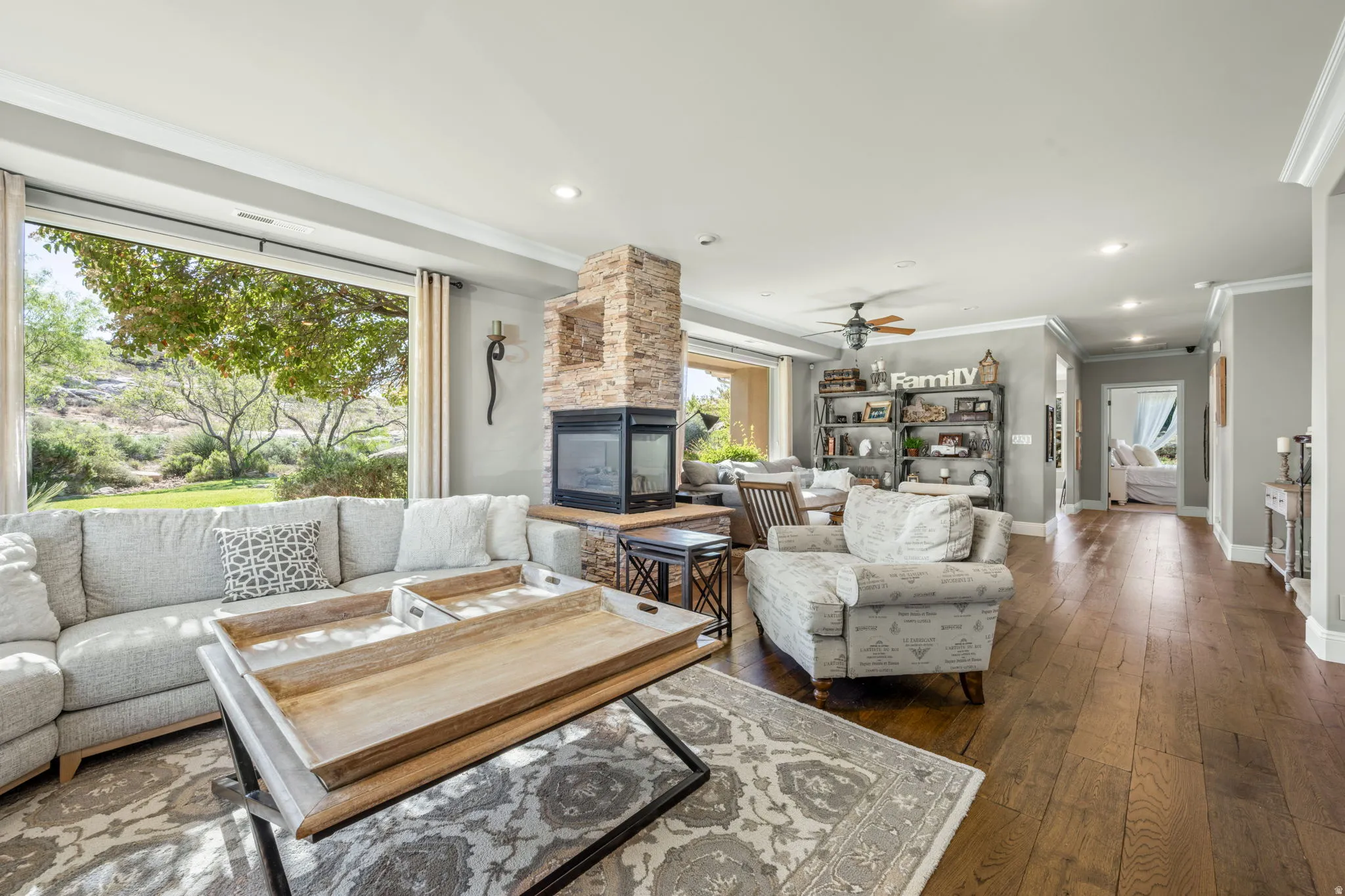 Living area with ornamental molding, dark wood-style floors, recessed lighting, a fireplace, and ceiling fan
