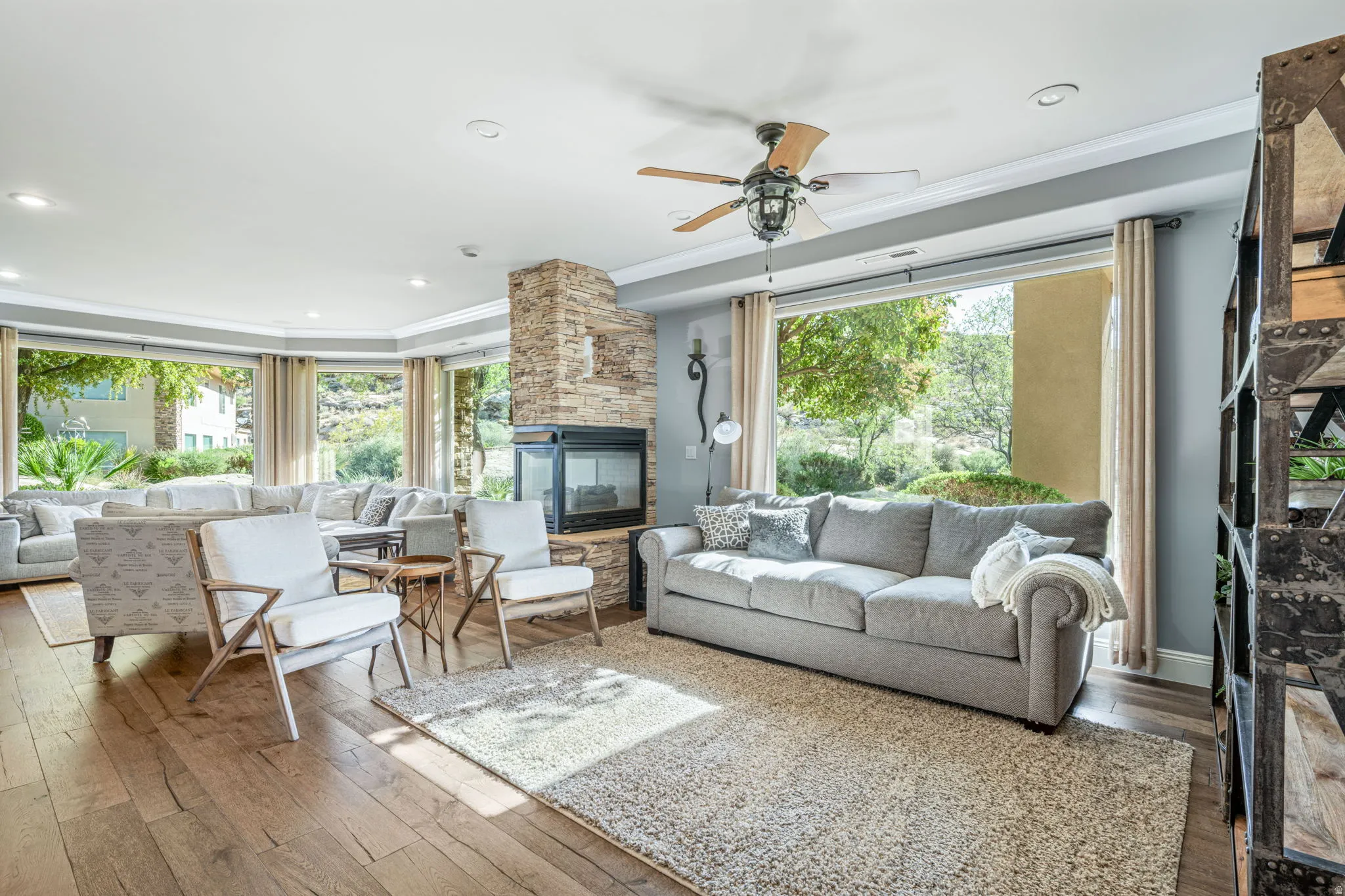 Living area featuring ceiling fan, hardwood / wood-style flooring, ornamental molding, a fireplace, and recessed lighting