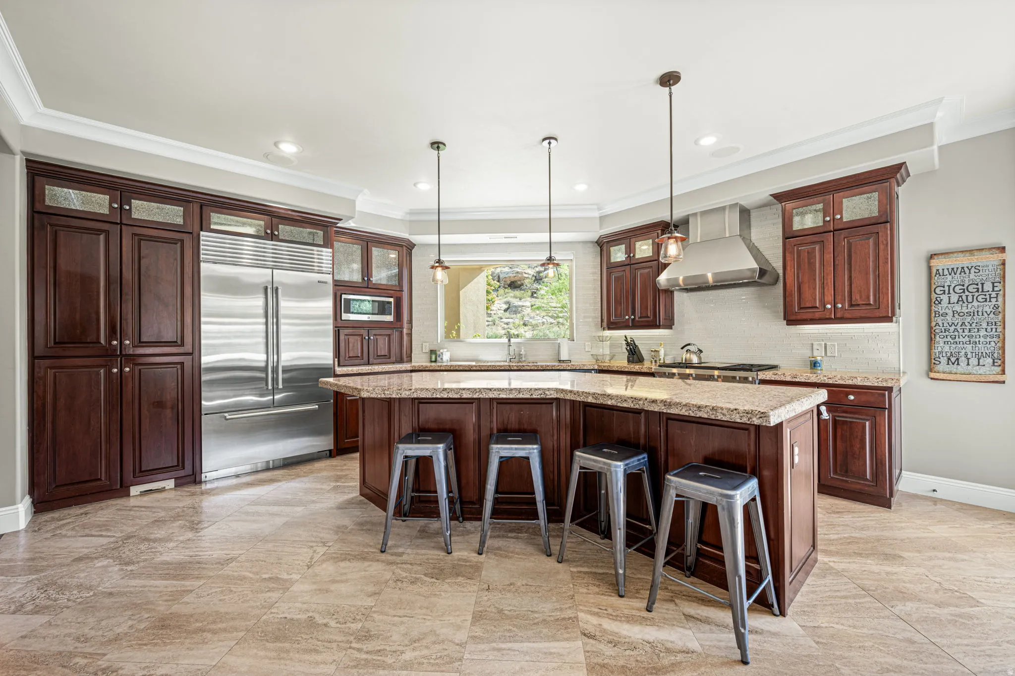 Kitchen with glass fronted cabinets, built in appliances, crown molding, a kitchen breakfast bar, and a kitchen island with sink