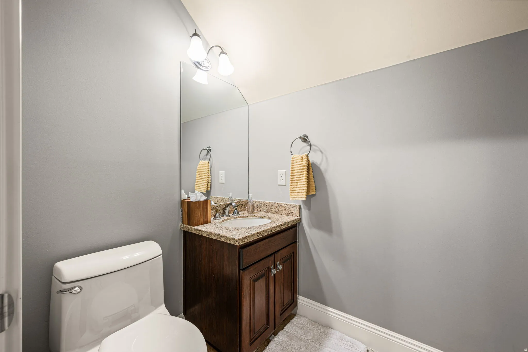 Half bathroom featuring vanity and toilet